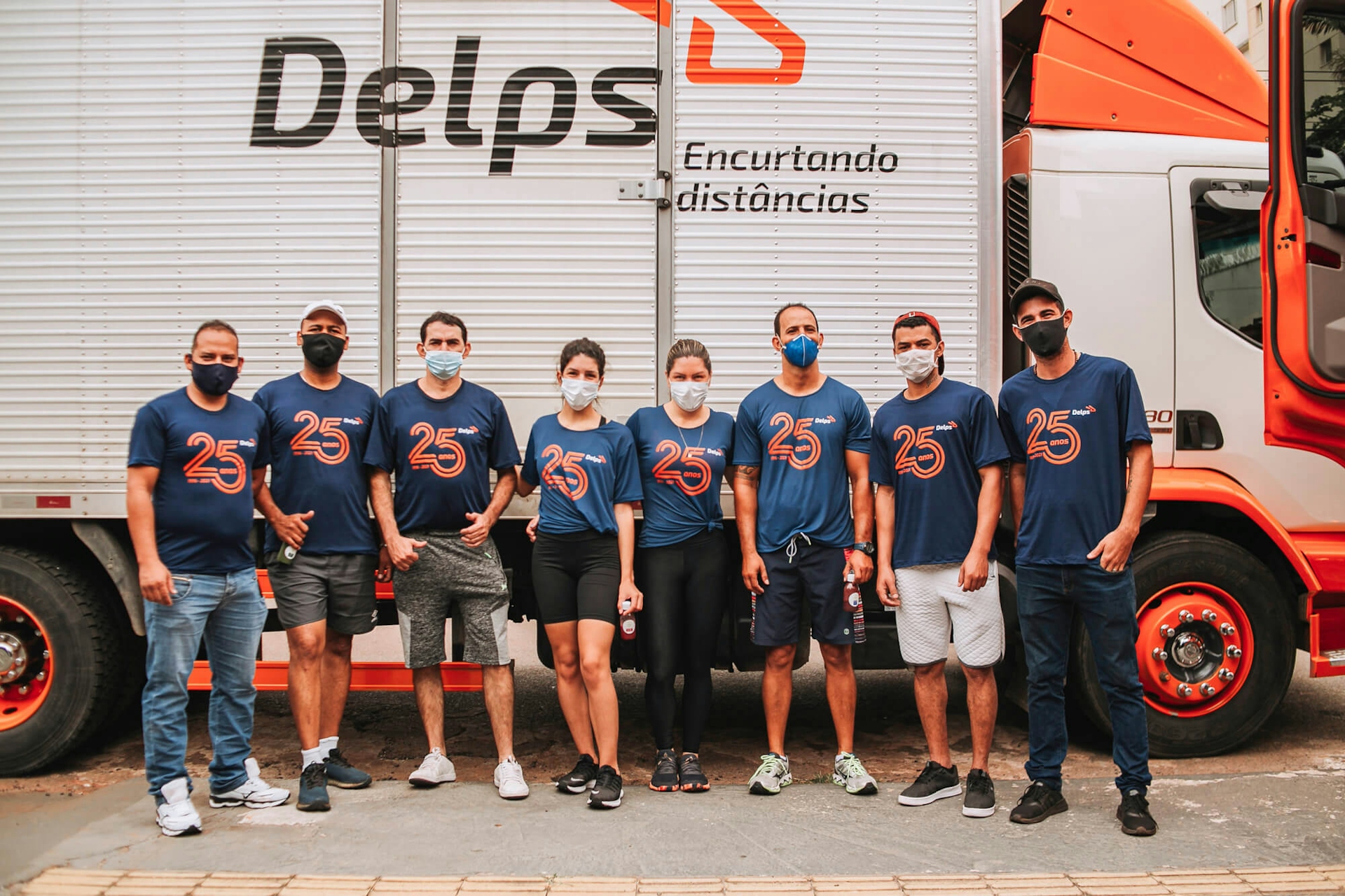 Foto da equipe da Delps em frente aos seus caminhões.