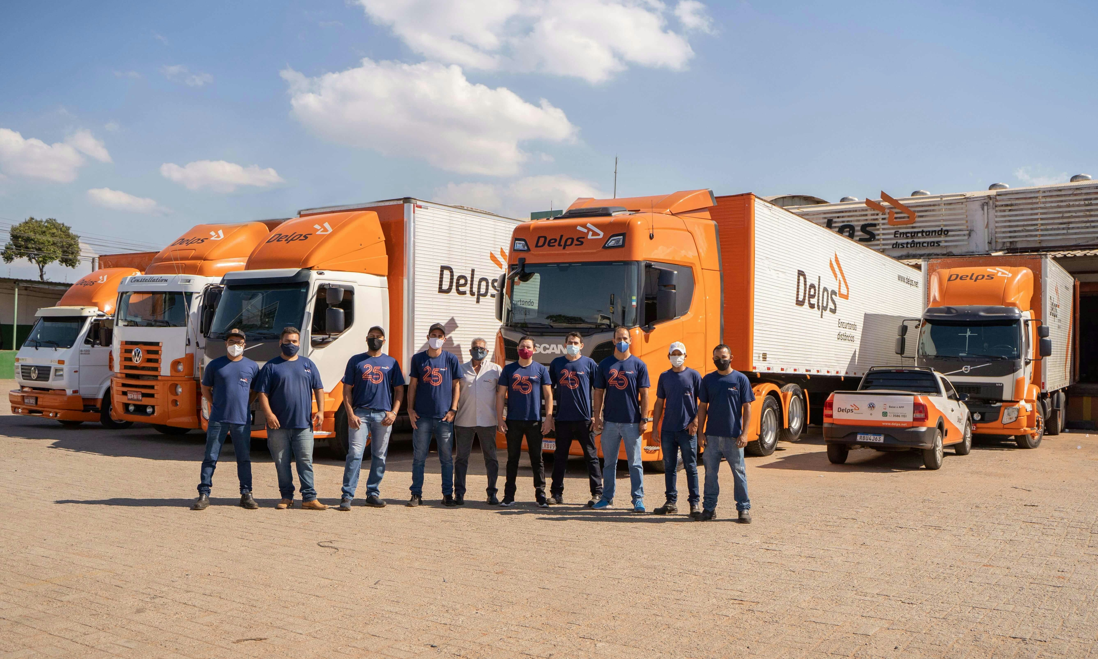 Foto de funcionários da Delps em frente aos caminhões